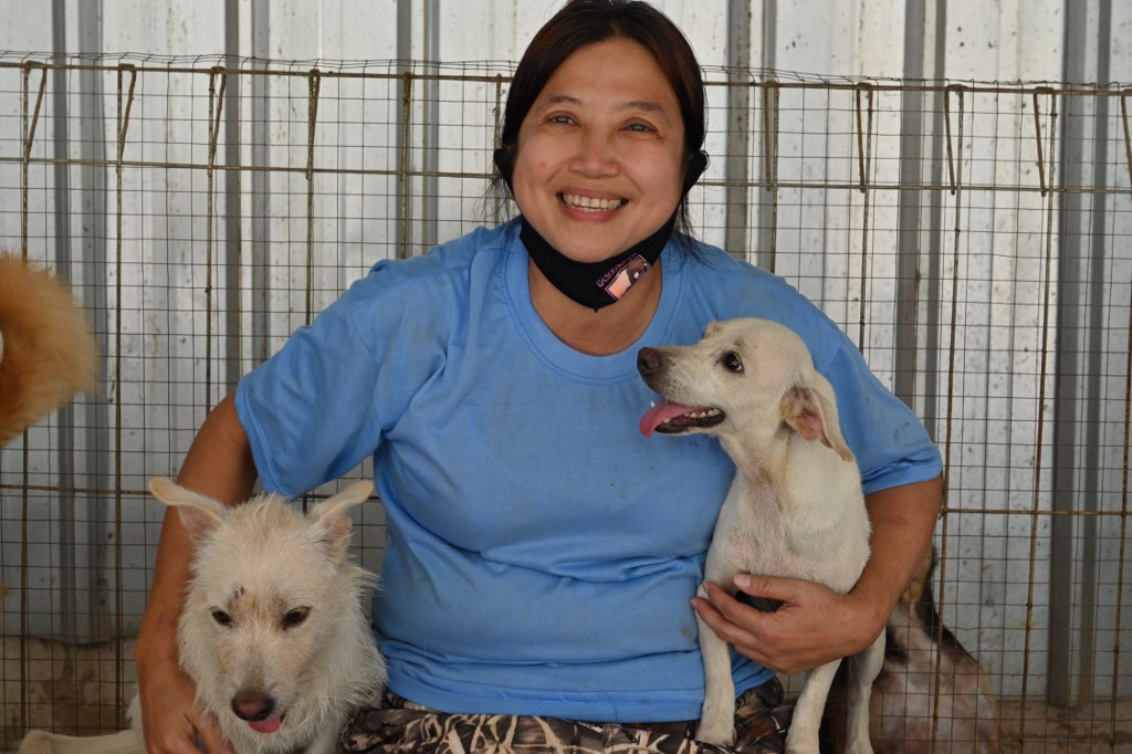 Woman cuddling two dogs