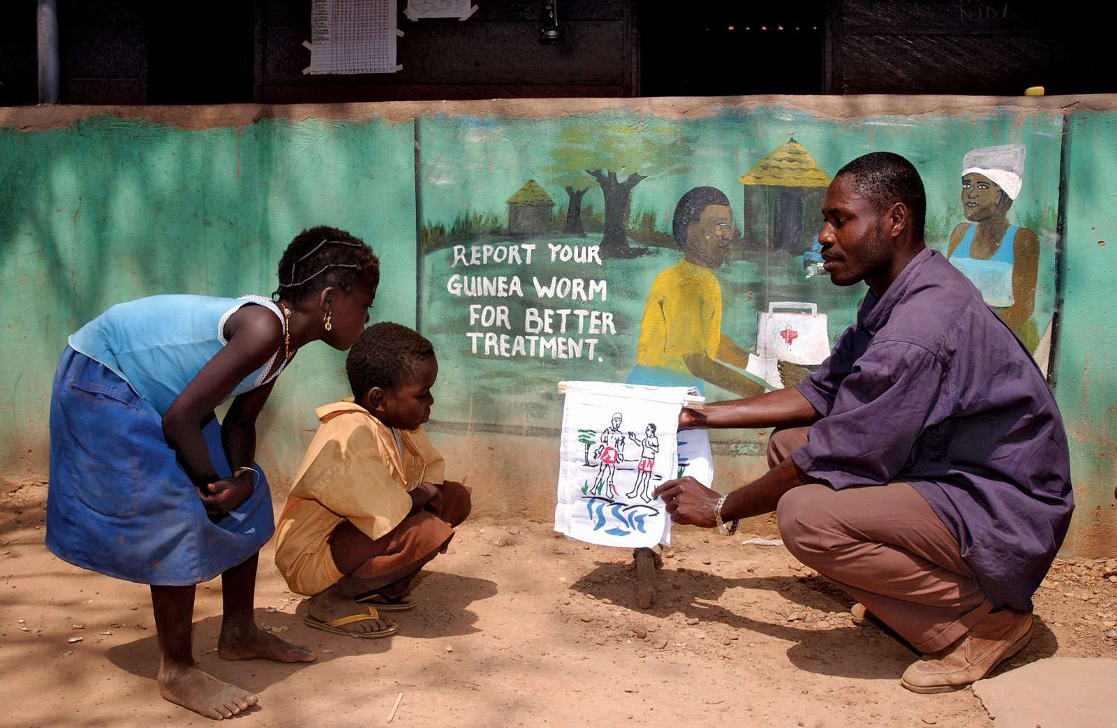 man showing kids info on Guinea Woem